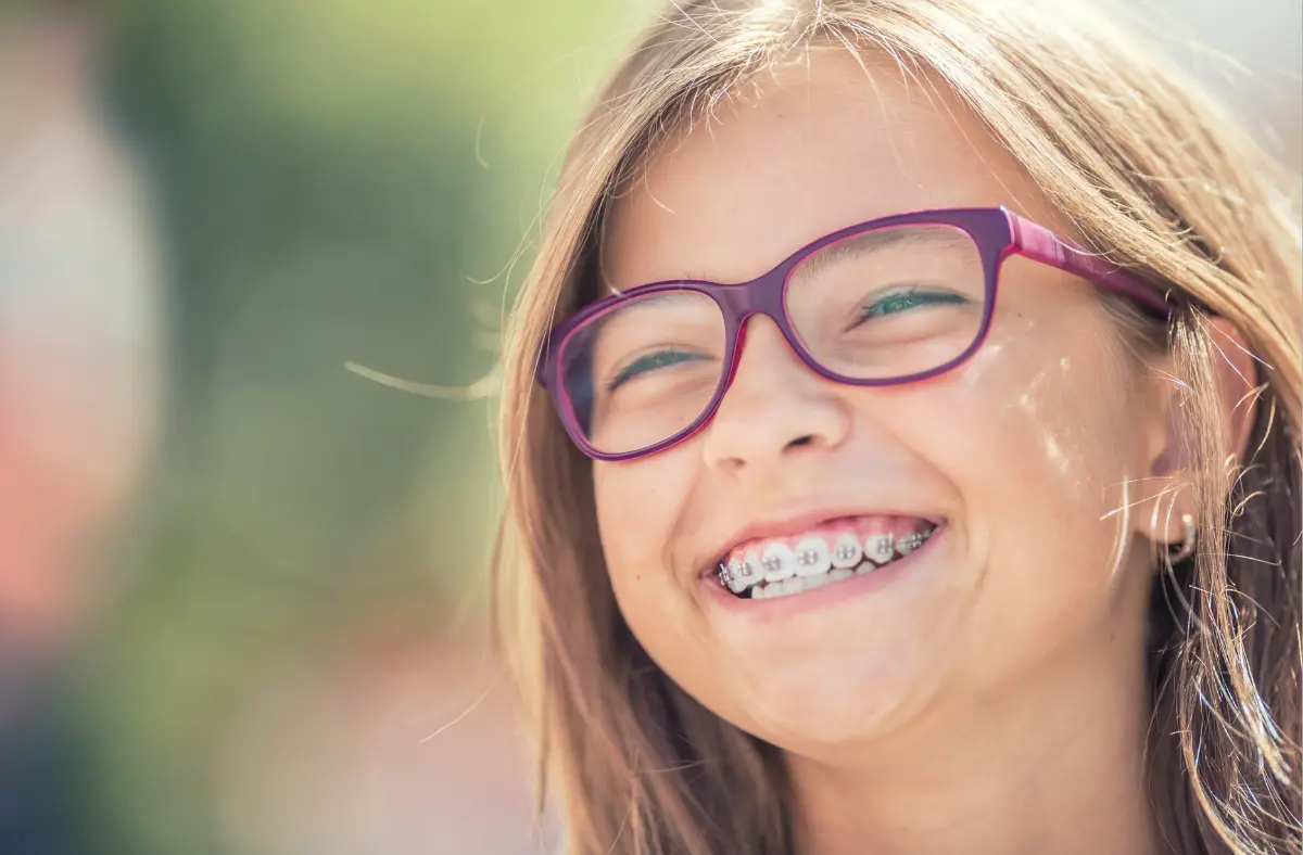 Child smiling with braces showing orthodontic treatment results