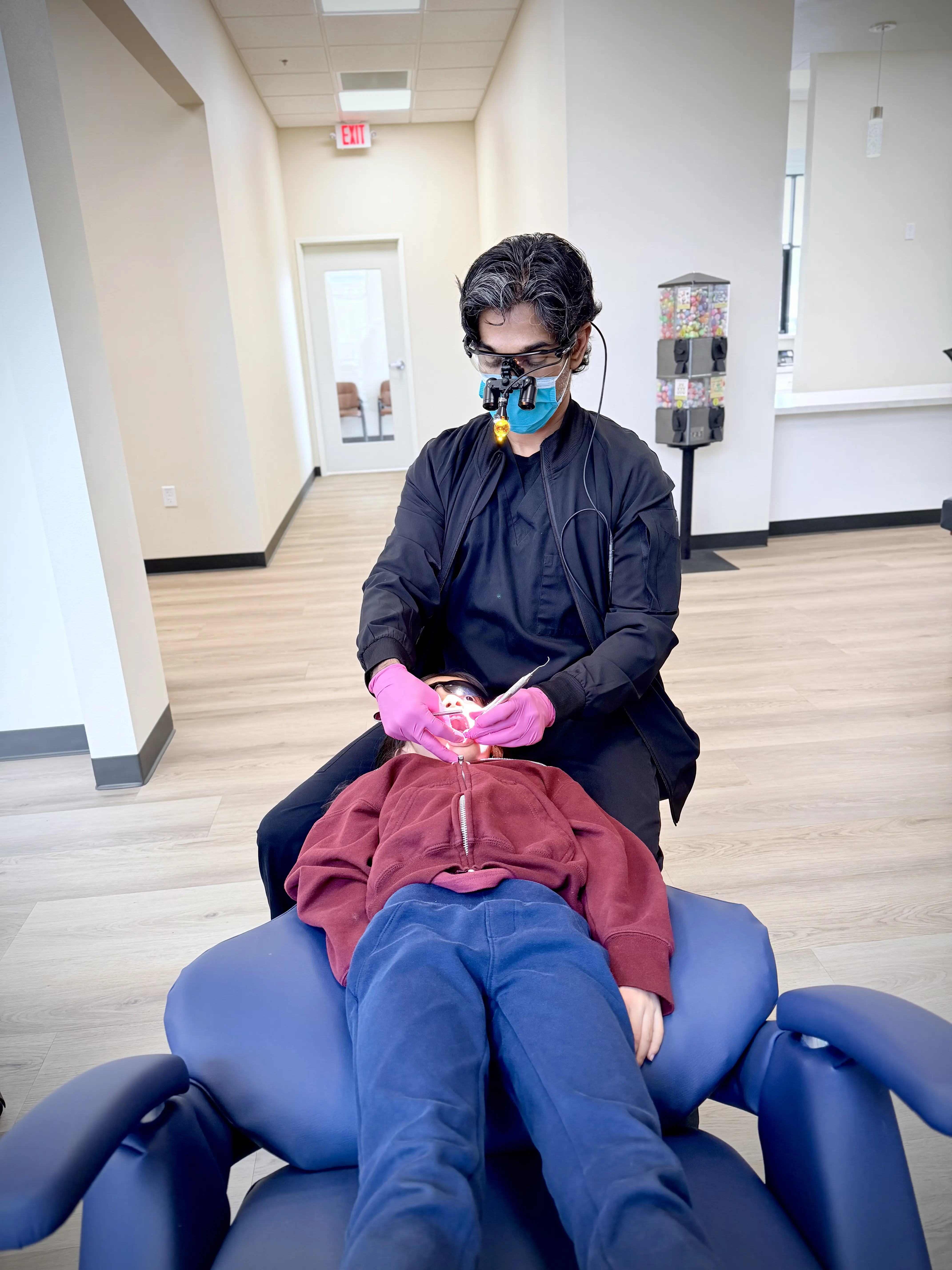 Pediatric dentist providing gentle emergency care to a child patient